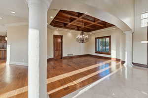 Foyer entrance with ornate columns, crown molding, coffered ceiling, recessed lighting, and hardwood / wood-style floors