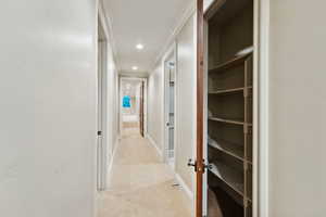 Hallway featuring light colored carpet, recessed lighting, and ornamental molding