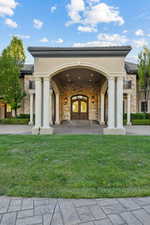 Property entrance with a lawn, stucco siding, and stone siding