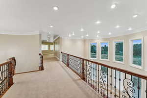 Hall featuring ornamental molding, light colored carpet, recessed lighting, and an upstairs landing