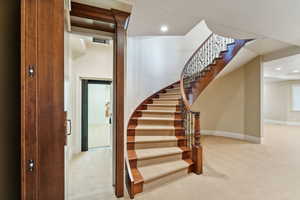 Stairs with carpet and recessed lighting