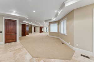 Below grade area with ornamental molding, light colored carpet, and recessed lighting