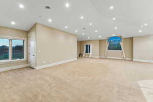 Unfurnished living room featuring light colored carpet, recessed lighting, and vaulted ceiling