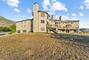 View of property with stairs and an attached garage