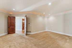 Spare room featuring light carpet, crown molding, and recessed lighting