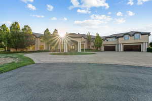View of front of property featuring curved driveway, stucco siding, and an attached garage