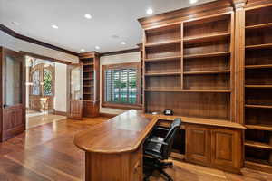 Office with built in desk, crown molding, light wood-style floors, and recessed lighting