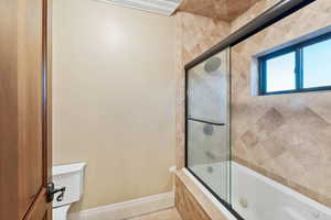 Bathroom with tiled shower / bath and crown molding