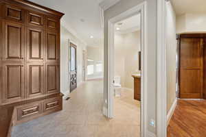 Hallway featuring ornamental molding, recessed lighting, and light tile patterned floors
