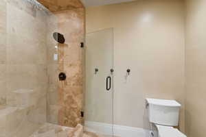 Full bath with a shower stall and toilet