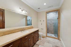 Full bathroom featuring vanity, crown molding, a shower stall, tile patterned flooring, and recessed lighting