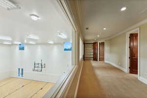 Hallway with carpet flooring, crown molding, and recessed lighting