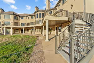 Back of property with stairs, a patio, and a chimney