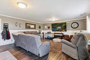 Living area featuring wood finished floors and ornamental molding