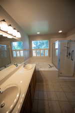 Bathroom featuring plenty of natural light, a tub with jets, a stall shower, tile patterned floors, and recessed lighting