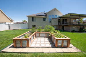 Rear view of house with a vegetable garden and solar panels