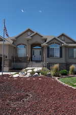 Ranch-style house featuring stone siding, stucco siding, and roof with shingles
