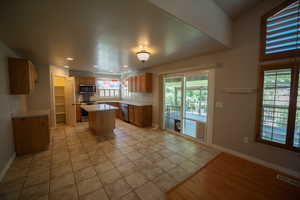 Kitchen with a kitchen island, light countertops, appliances with stainless steel finishes, recessed lighting, and light tile patterned floors