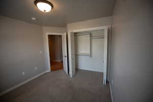 Unfurnished bedroom featuring carpet and a closet