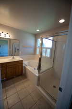 Full bath featuring a garden tub, vanity, tile patterned floors, a stall shower, and recessed lighting