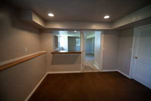 Hallway with carpet flooring, recessed lighting, and tile patterned flooring