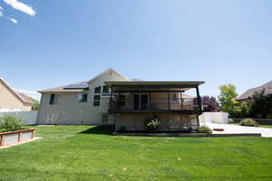 Rear view of house with roof mounted solar panels, driveway, and a wooden deck