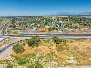 Aerial perspective of suburban area featuring a main thoroughfare and a mountain backdrop
