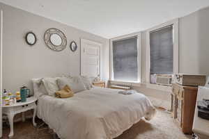 Bedroom featuring carpet flooring and cooling unit