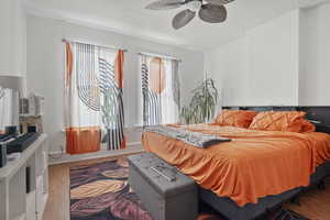 Bedroom featuring a ceiling fan, a textured ceiling, and wood finished floors