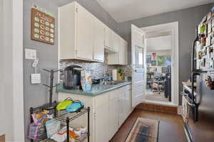 Kitchen featuring wood finished floors, freestanding refrigerator, electric stove, and backsplash