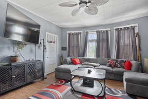 Living room with wood finished floors and a ceiling fan