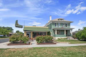View of front of property featuring a chimney, a front yard, and a porch