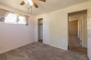 Unfurnished bedroom featuring carpet, a closet, ceiling fan, and ornamental molding