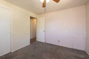Carpeted spare room with ceiling fan and crown molding
