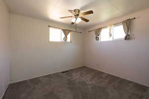 Carpeted empty room featuring crown molding and ceiling fan