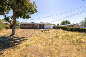 Back of property featuring an attached garage and brick siding