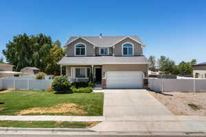 Traditional home featuring a porch, driveway, a garage, stucco siding, and a shingled roof