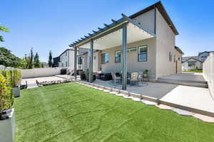 Rear view of house featuring a patio area, a fenced backyard, and an outdoor living space