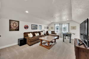 Bedroom 4 or Bonus room with 2 closets, light colored carpet, vaulted ceiling, a textured ceiling, and recessed lighting