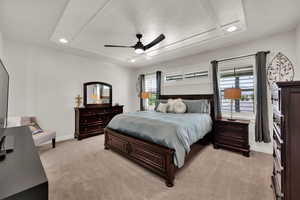 Primary ensuite featuring a coffered ceiling with recessed lighting, light carpet, 4.5" planation shutters and a ceiling fan