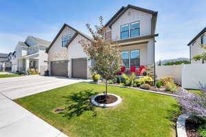 Craftsman-style house featuring board and batten siding, stone, covered porch, and driveway