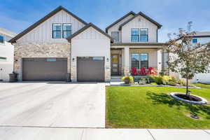View of front of home featuring board and batten siding, a porch, and a front yard