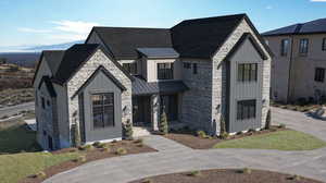 Modern farmhouse style home with stone siding, a metal roof, a standing seam roof, a shingled roof, and board and batten siding