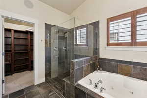 Bathroom featuring a stall shower and a tub with jets