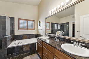 Full bathroom featuring a stall shower, double vanity, a bath, and tile patterned floors