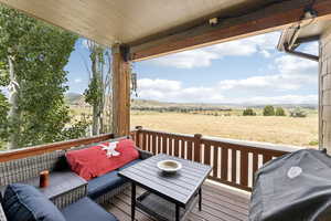 Wooden terrace featuring a grill, a view of rural / pastoral area, and an outdoor hangout area