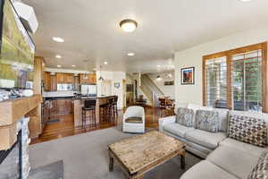 Living room with stairway, recessed lighting, and wood finished floors