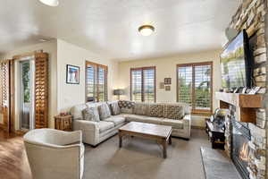 Living room with a fireplace, plenty of natural light, and a textured ceiling