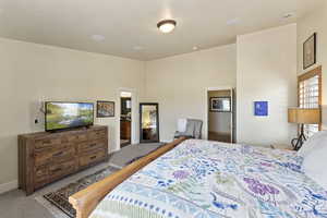 Carpeted bedroom featuring baseboards and a high ceiling