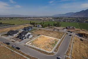 Aerial view of property and surrounding area with property parcel outlined and a mountainous background
